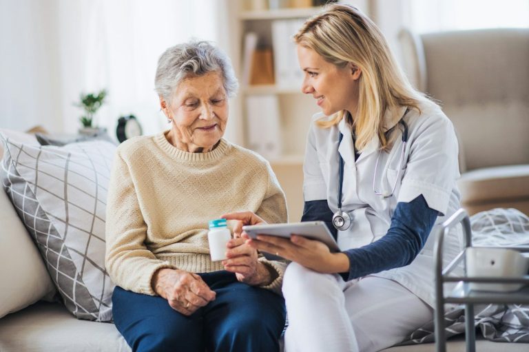 A healthcare professional consults with an elderly woman at home.